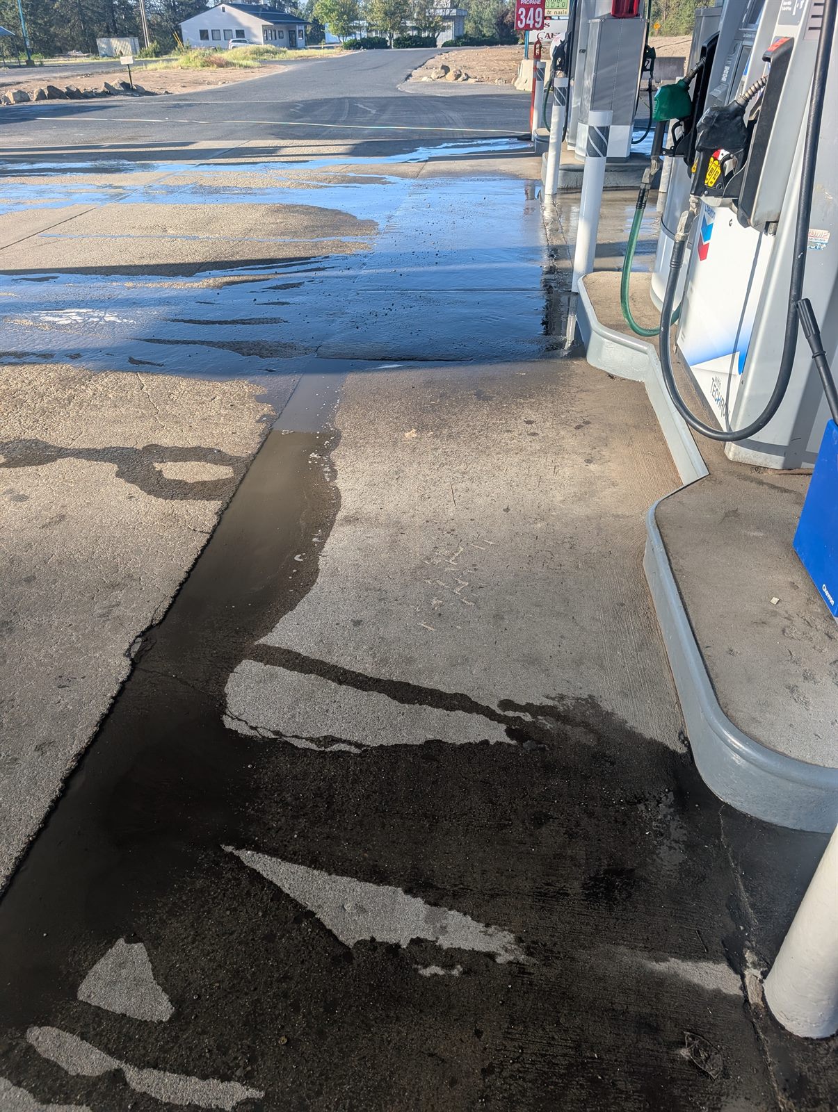 Before pressure washing Spokane - dirty concrete gas pad with algae